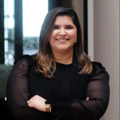 Retrato profesional de una mujer con vestido negro, brazos cruzados